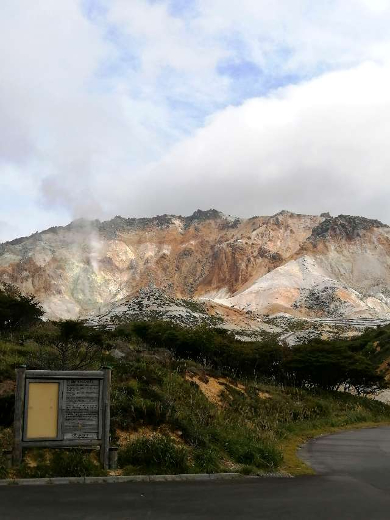 title :『 【北海道車中泊】サイロ展望台〜恵山〜道の駅なないろななえ 』画像説明文 :結構急な登りでやや道幅が狭く観光バスはキビシイかな？標高300mにある恵山 賽の河原駐車場までの道のりはカーブも多く大型車との離合は厳しい道が続いていました。恵山の賽の河原駐車場に着いたのが午後１時、曇りながらも少し晴れ間も見えています。