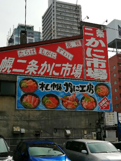 title :『 【北海道車中泊】札幌市役所〜室蘭〜道の駅だて歴史の杜へ 』画像説明文 :札幌市役所に来たのは展望回廊に行ってみようということだったのだけど何せ時間が早すぎる。展望回廊は9:30分からなのでまだ１時間もありさてどうしょうか？と思案していたら駐車場係が「そのあたりブラブラしていいよ〜！」と言うのでお言葉に甘えることにした。札幌市役所から札幌二条市場まで歩いて行けそうなので時間潰しに札幌二条カニ市場に行くことに...札幌二条市場およそ10分で札幌二条市場に到着しました。この札幌二条市場には駐車場はあるけど数台しか止められないので歩いて正解だと思う。